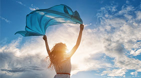 photo : Beautiful young woman on sunset background with blue tissue.