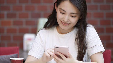 スマートフォンを操作する女性の写真