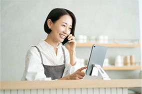 タブレットを見ながら予約を受けている女性